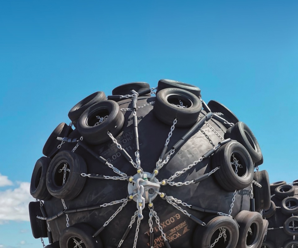 Yokohama pneumatic fenders with tyre net protection against clear blue sky