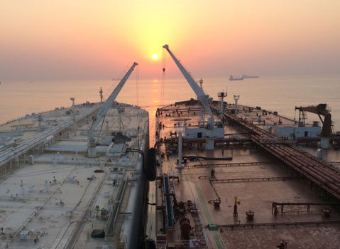 Ship-to-ship transfer with sunset